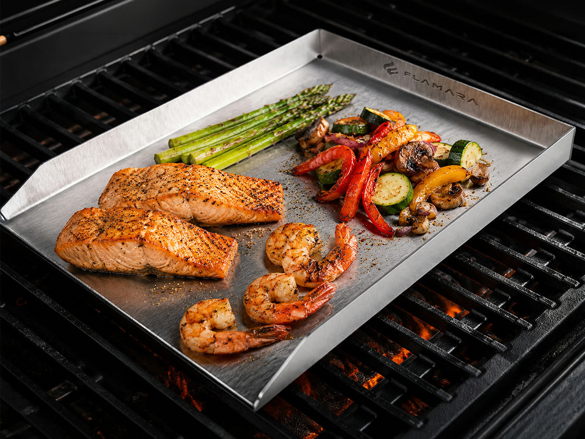 Edelstahl-Plancha mit Lachs, Garnelen und Gemüse auf einem Gasgrill