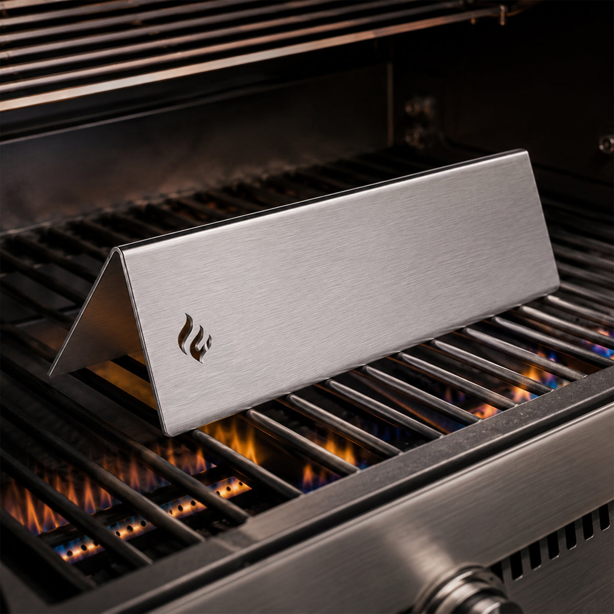 Flamara Aromaschiene aus 1,5 mm Edelstahl auf dem Brenner eines Weber Gasgrills, mit lasergeschnittenem Flammensignet